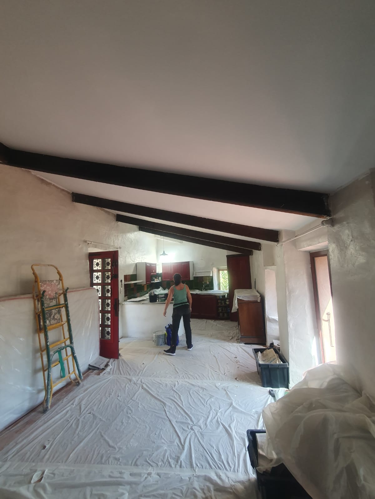 Armelle Jodts, artisan peintre en bâtiment, rénovant un salon avec poutres apparentes dans les Pyrénées-Orientales