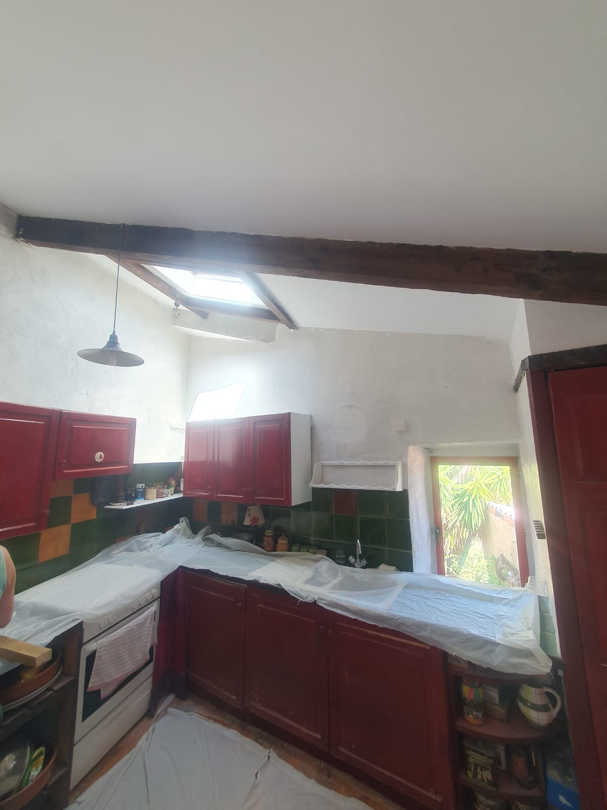 Cuisine avec éléments rouges et carrelage artisanal — décoration luxueuse intérieure dans les Pyrénées-Orientales