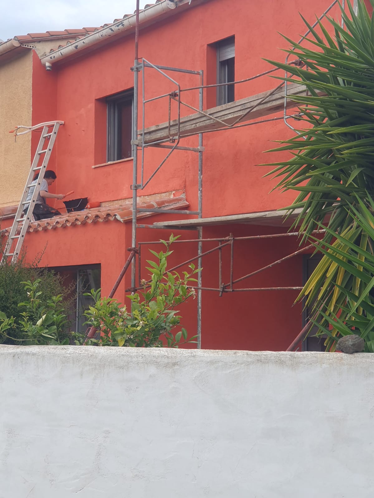 Ravalement en cours — échafaudage et application d'enduit sur façade dans les Pyrénées-Orientales